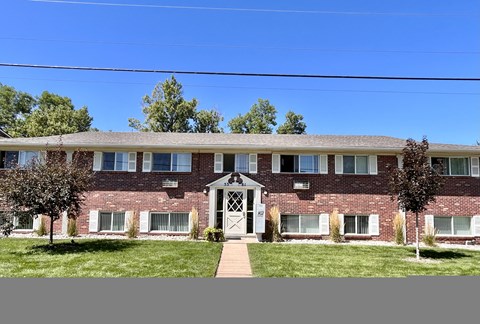 A red brick building with a white door and windows.