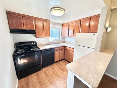 A kitchen with black appliances and wooden cabinets.