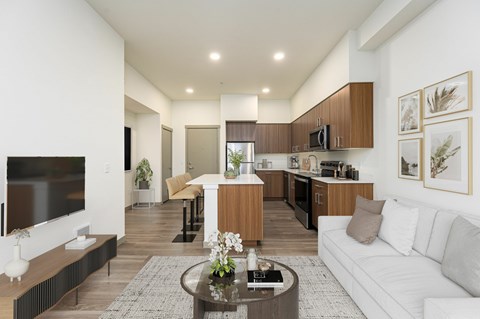 A modern living room with a white couch and a coffee table in the center.