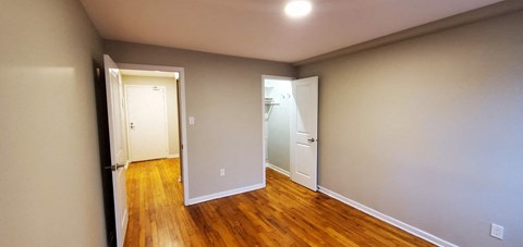 A hallway with wood floors and white walls.