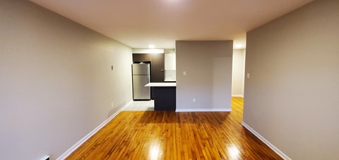 A long hallway with a kitchen area at the end.