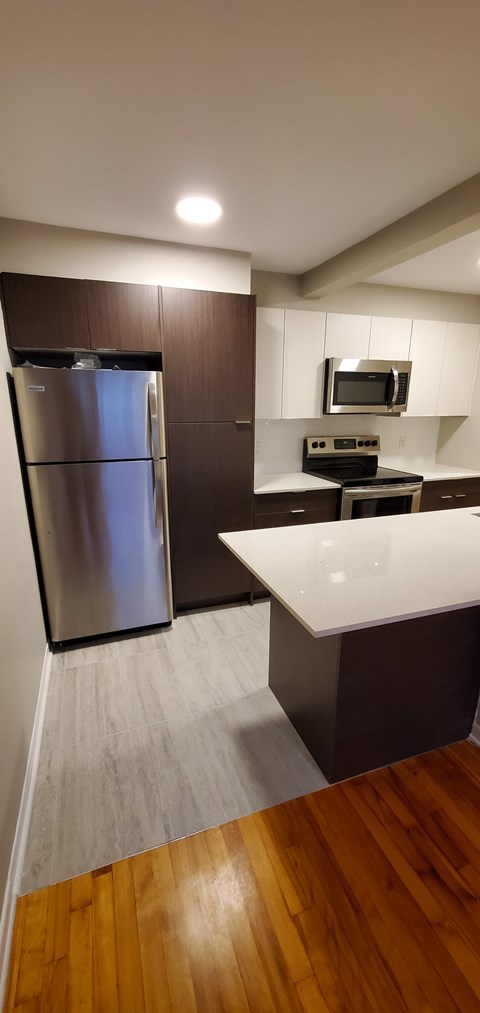 A kitchen with a refrigerator and a microwave.
