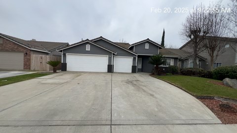 A residential house with a grey garage door is captured in the image.