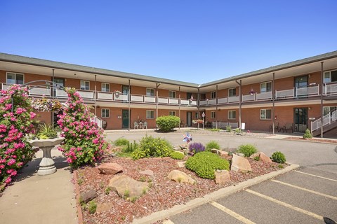 A building with a balcony and a garden in front.
