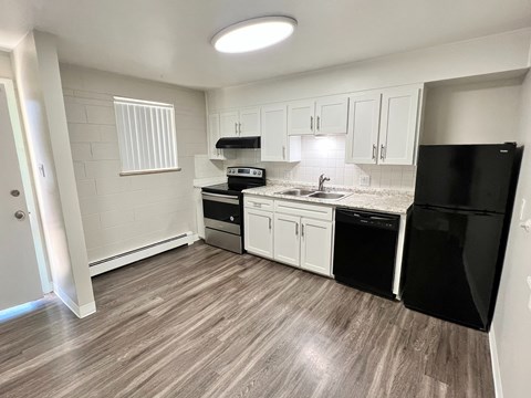 A kitchen with black appliances and white cabinets.