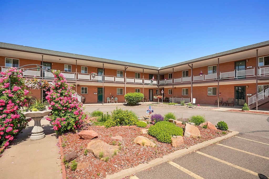 A building with a balcony and a garden in front.