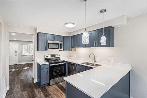 A kitchen with dark blue cabinets and a white counter.
