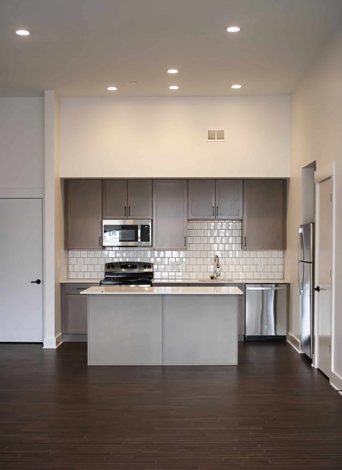A modern kitchen with a large island and stainless steel appliances.
