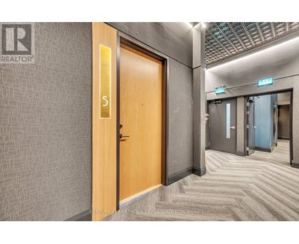 A hallway with a wooden door numbered 5.