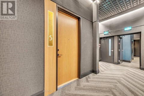 A hallway with a wooden door numbered 5.
