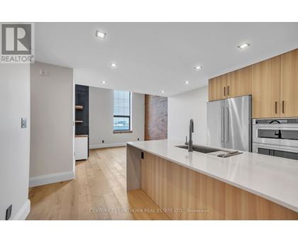 A modern kitchen with wooden cabinets and stainless steel appliances.
