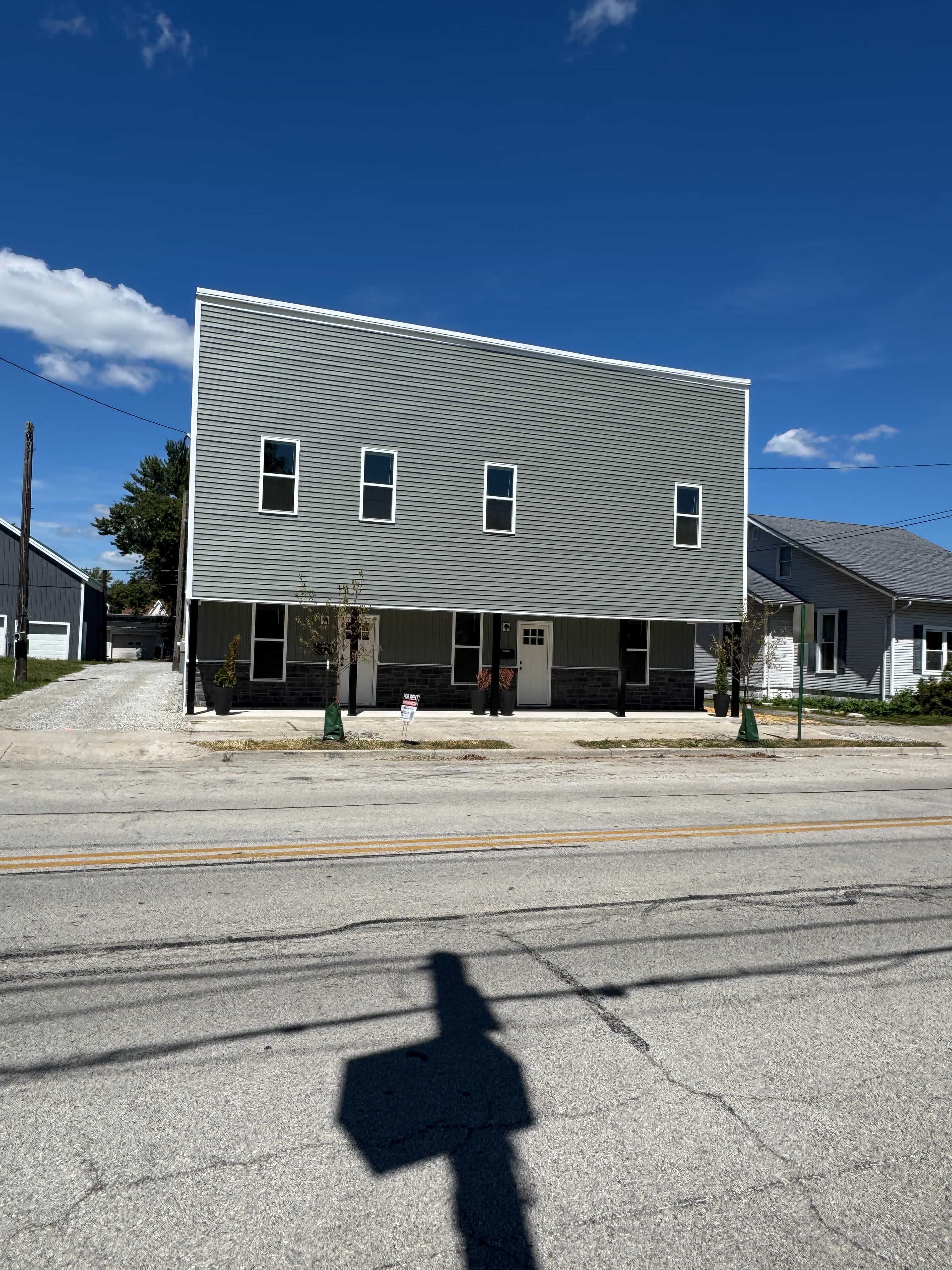 A grey building with a shadow of a person in front of it.