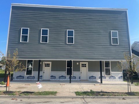 A house under construction with a sign in front that says "Louie's".