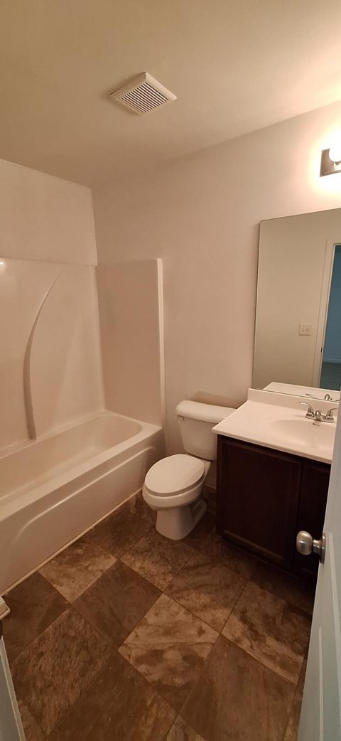 A bathroom with a toilet, sink, and bathtub.