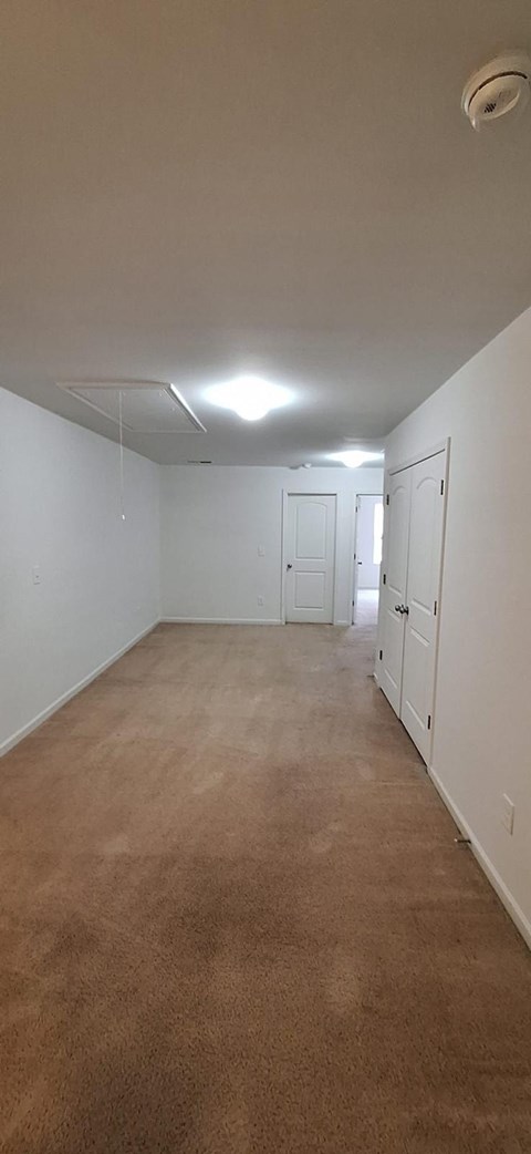 A room with white walls and carpeted floor.