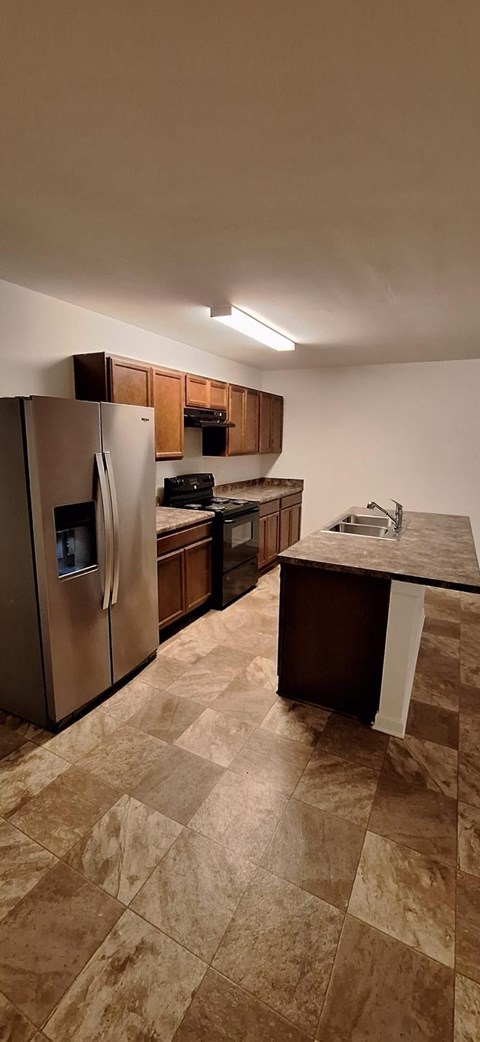 A kitchen with a refrigerator, stove, and countertop.