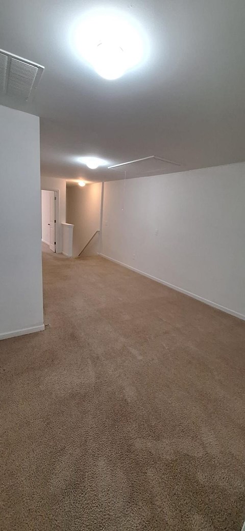 A room with a carpeted floor and a white wall.