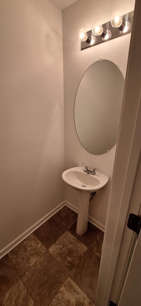 A bathroom with a sink and a mirror.