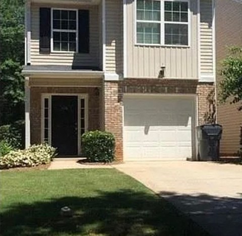 A two-story house with a garage door and a black door.