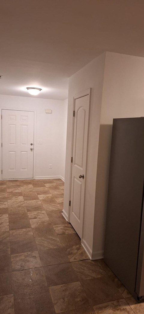 A hallway with a tiled floor and two doors.
