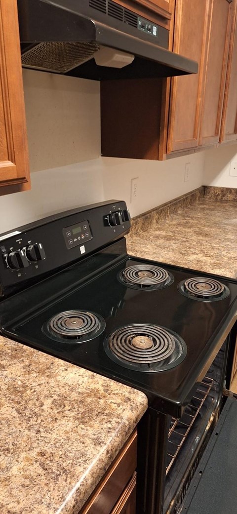 A black stove top oven with four burners.