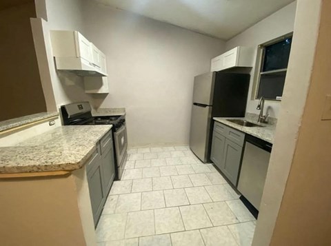 A kitchen with white tiled floors and a countertop.