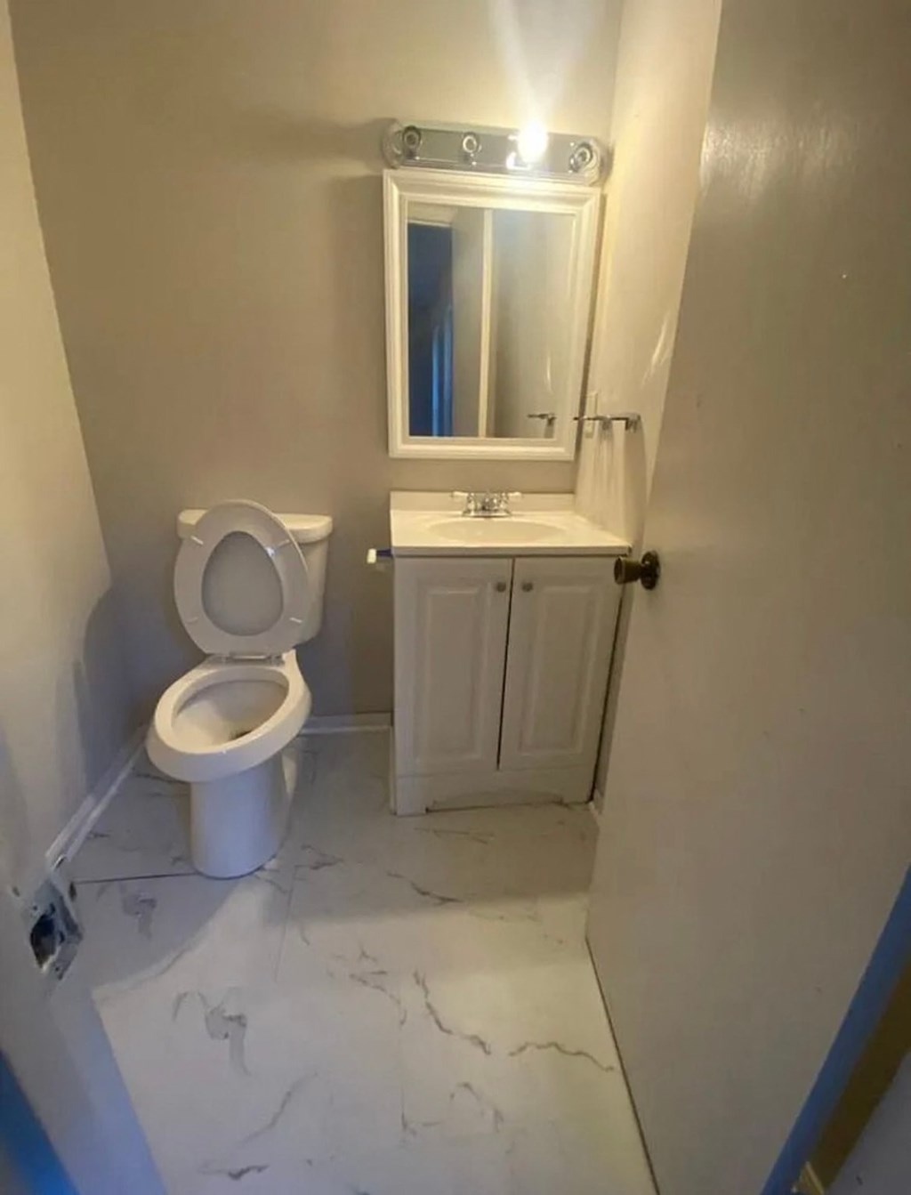 A white toilet sits next to a sink in a small bathroom.