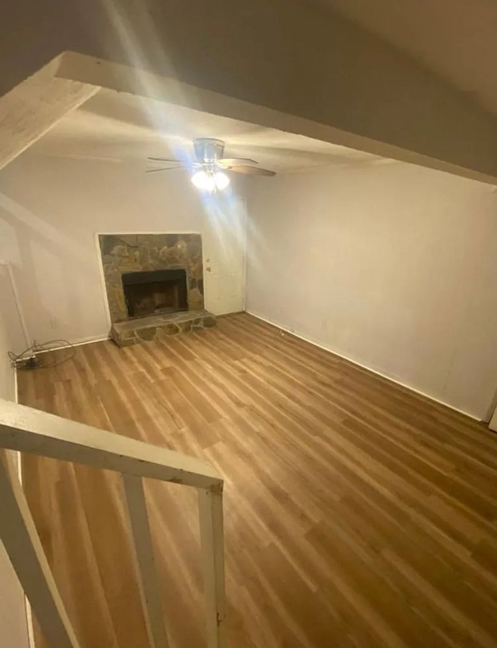 A room with a fireplace and wooden flooring.