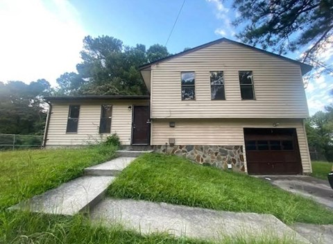 A house with a stone wall and a garage door.