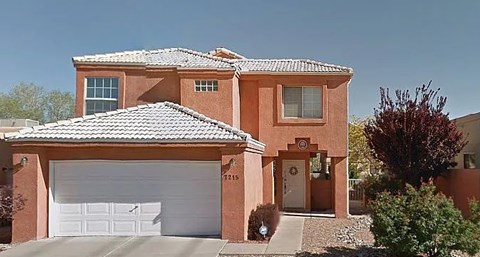 A house with a red brick exterior and a white garage door.