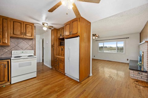 A kitchen with wooden cabinets and a white stove top oven.