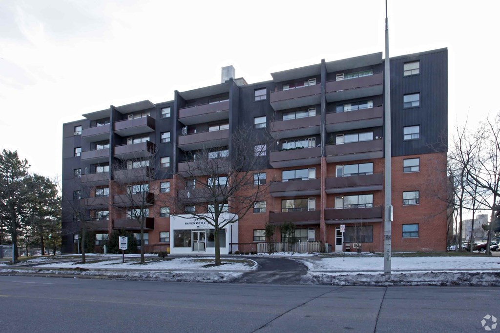 A large apartment building with a tree in front of it.