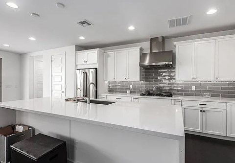 A modern kitchen with white cabinets and a large island.