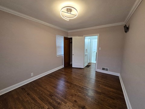 A room with wooden floors and a ceiling light.