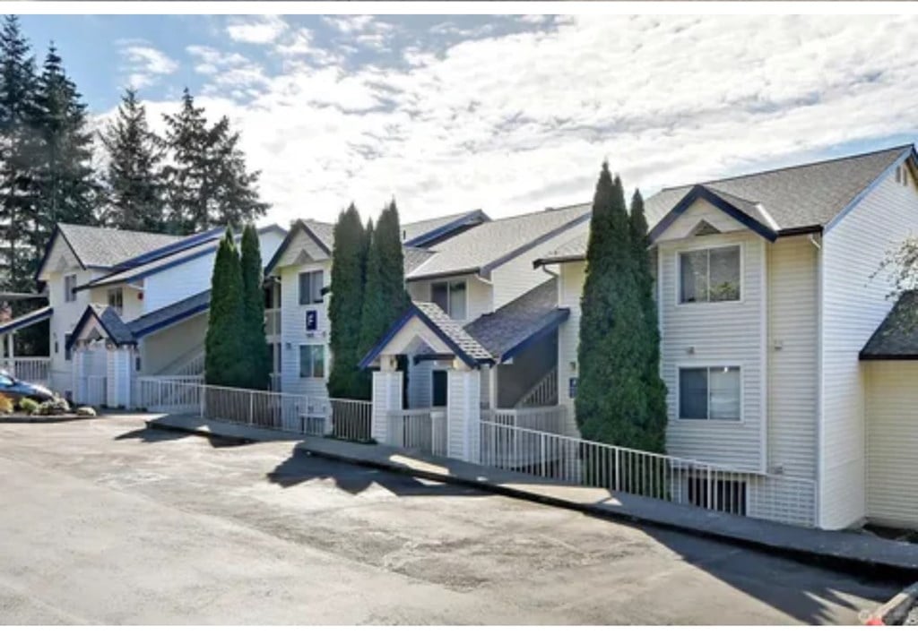 A row of houses with a white picket fence in front.