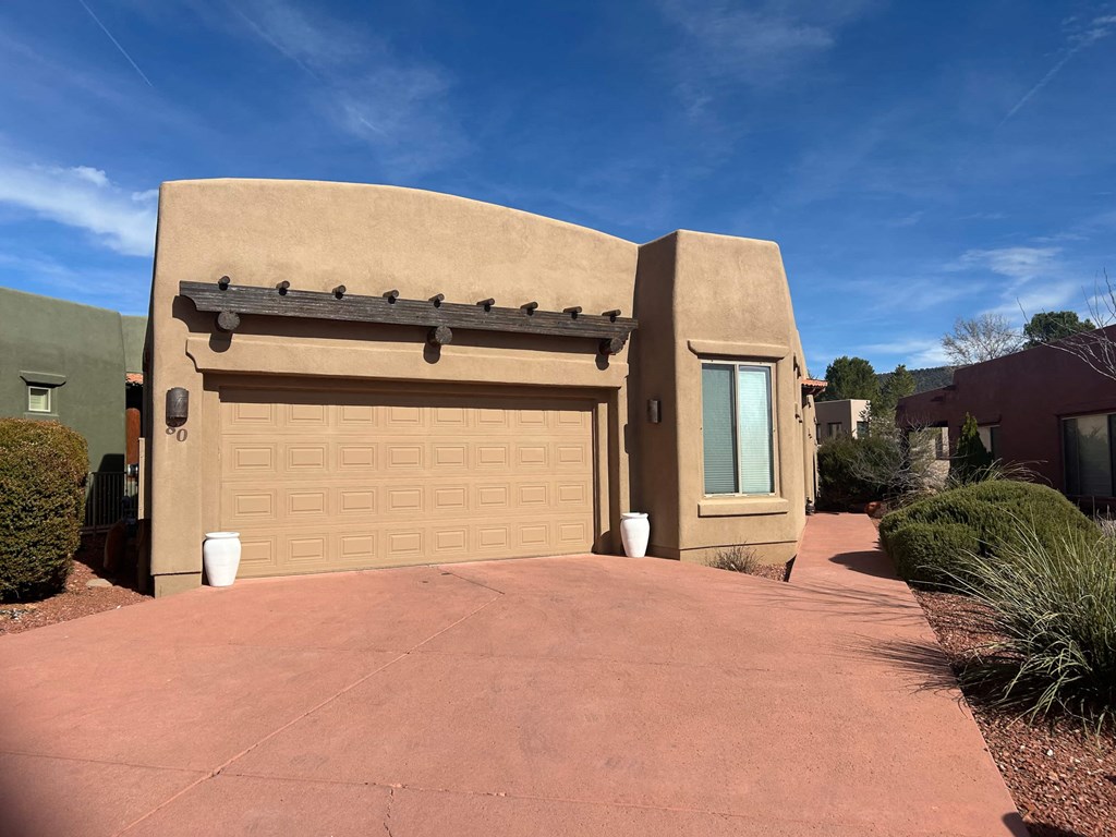 A house with a tan garage door and a brown roof.