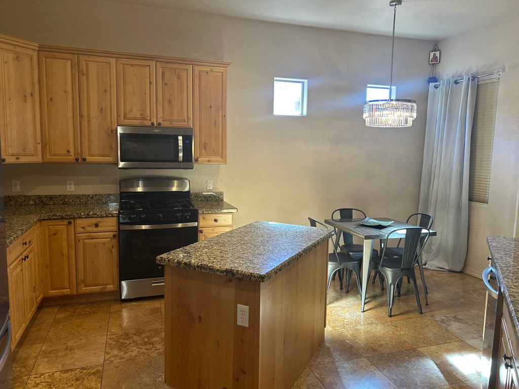 A kitchen with wooden cabinets and granite countertops.