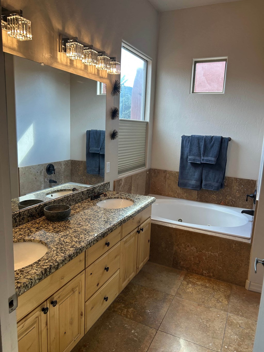 A bathroom with a tub, sink, and mirror.