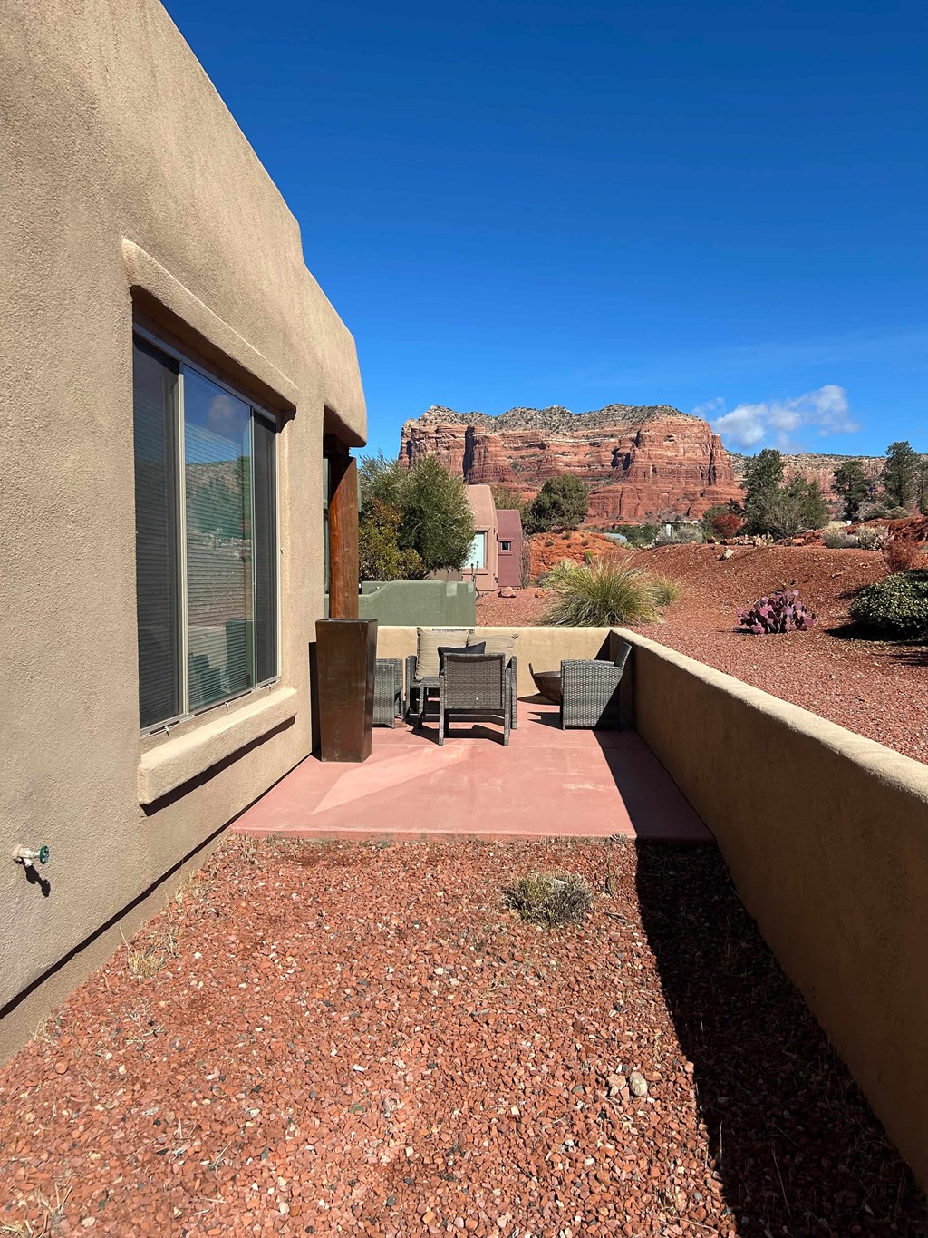 A balcony with a table and chairs overlooking a desert landscape.