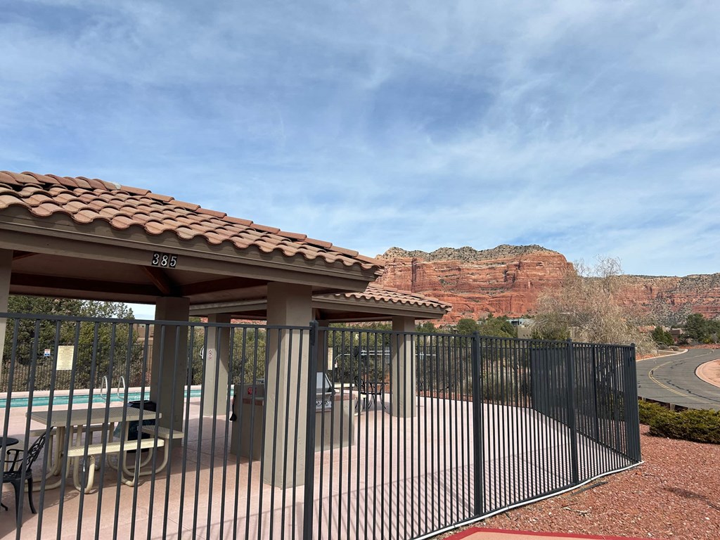 A pool area with a gate and a mountain in the background.