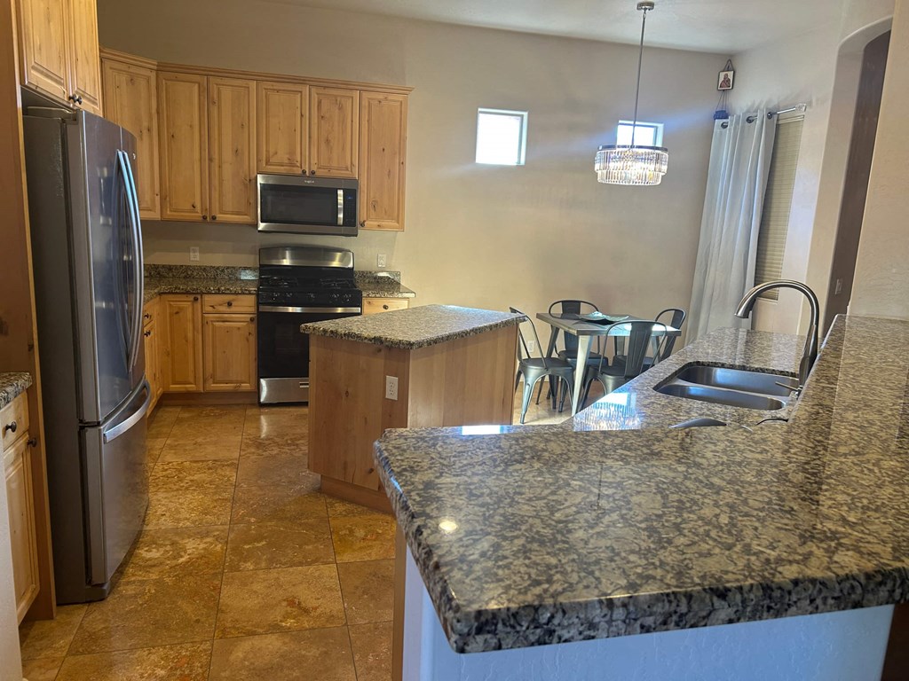 A kitchen with granite countertops and wooden cabinets.