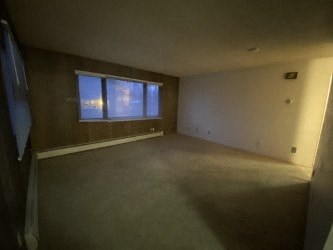 Empty room with a window and a door on the left.