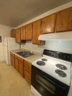 A kitchen with a white stove top oven and a white refrigerator.