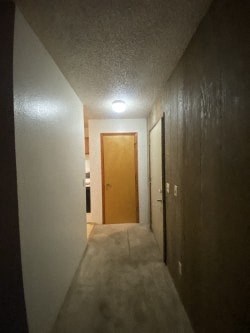A hallway with a light on the ceiling and a door at the end.