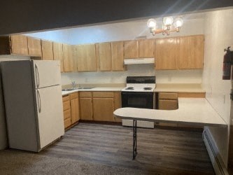 A kitchen with a white refrigerator and a white counter.