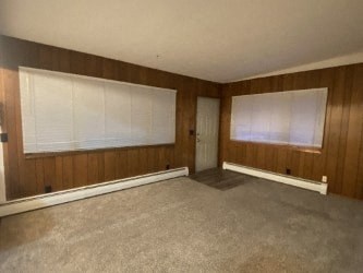 A room with a carpeted floor and a door.