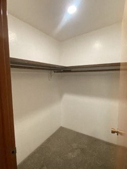 A small, empty room with a door on the left and a grey floor.