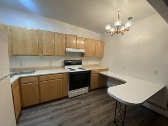 A kitchen with wooden cabinets and a white stove top oven.
