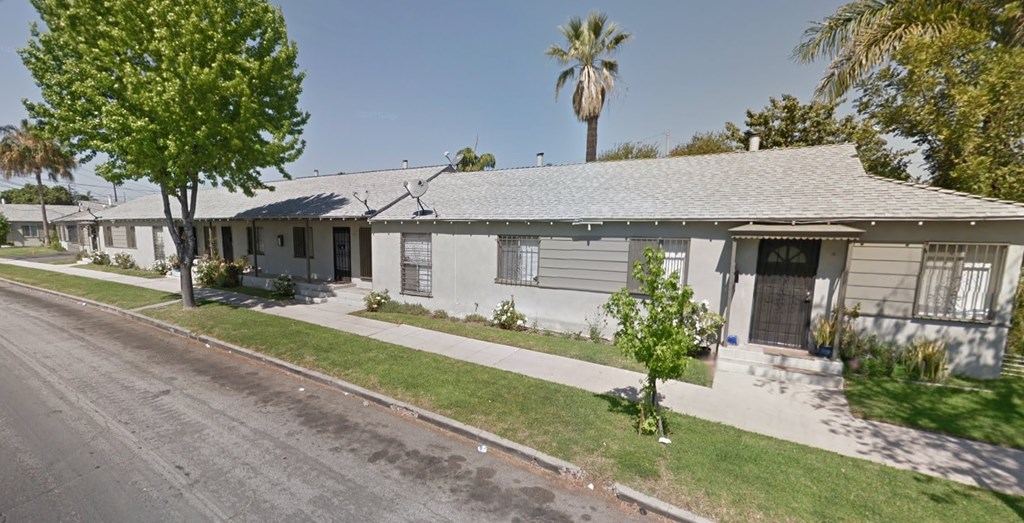 A row of houses with a tree in front of the first house.