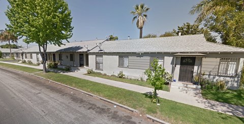 A row of houses with a tree in front of the first house.